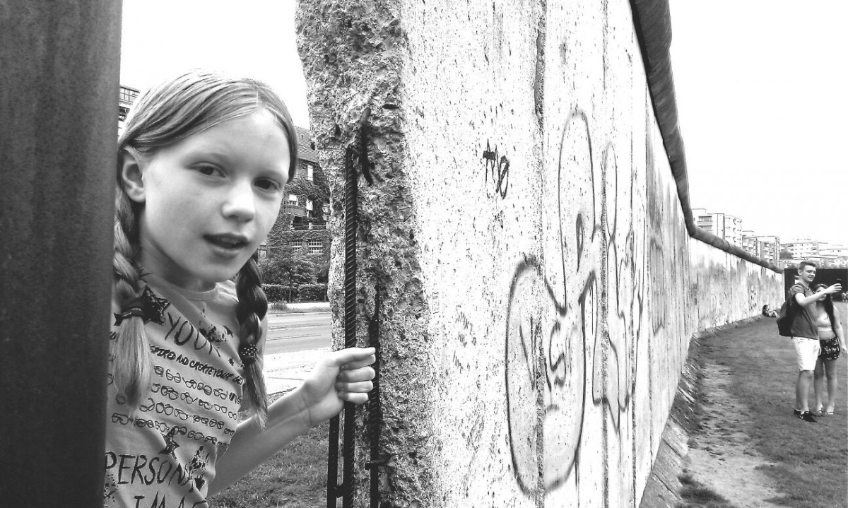 Kind guckt durch B Mauer Kind guckt durch B Mauer